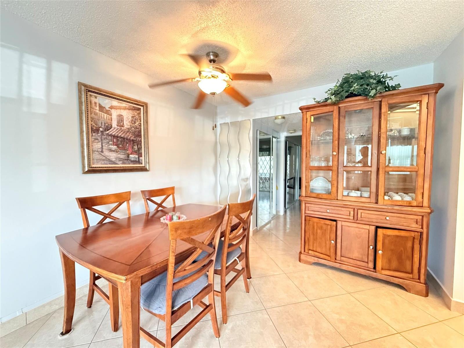 A dining room features a wooden table, four chairs, and a matching hutch on tile flooring — 53 Markham C # 53, Deerfield Beach FL 33442, DEERFIELD BEACH, FL