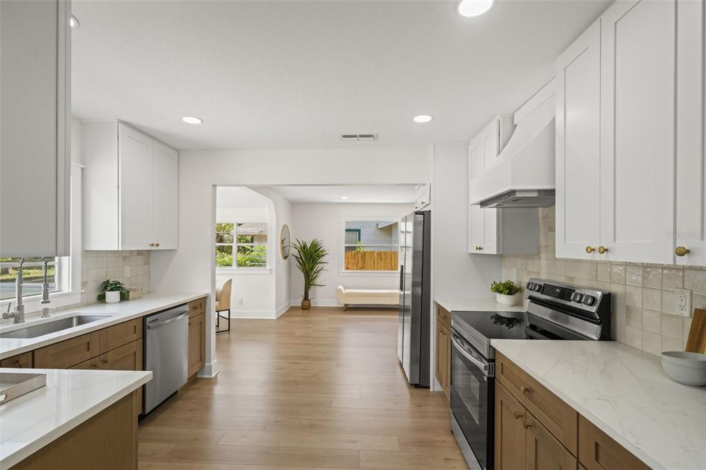 A kitchen with white upper cabinets, wood lower cabinets, and stainless steel appliances — 3036 20TH STREET N, ST PETERSBURG, FL