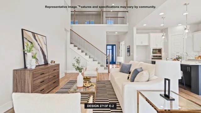 This rendering shows an open-concept living room with a staircase, white sofa, and kitchen — 294 HOLLY BANK AVENUE, NOKOMIS, FL
