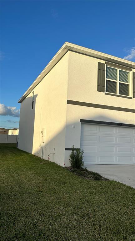 A two-story house with a white stucco exterior, a two-car garage, and a front lawn — 33503 ELM HILL BRANCH, WESLEY CHAPEL, FL