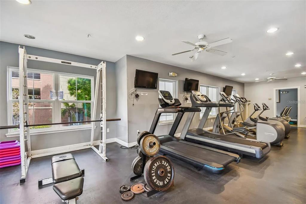 An open-concept living and dining area features hardwood floors, a staircase, and a kitchen pass-through — 204 SOUTH STREET UNIT 1053, ORLANDO, FL