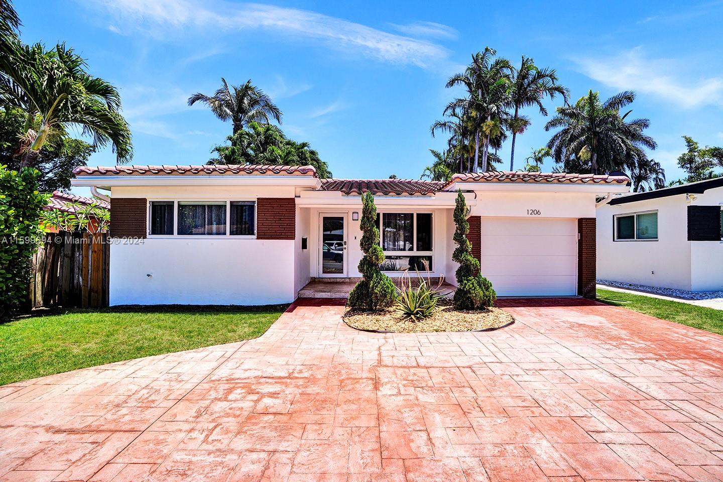 A single-story house with a white exterior, brown brick accents, and a red paved driveway — 1206 Lincoln St, Hollywood FL 33019, HOLLYWOOD, FL