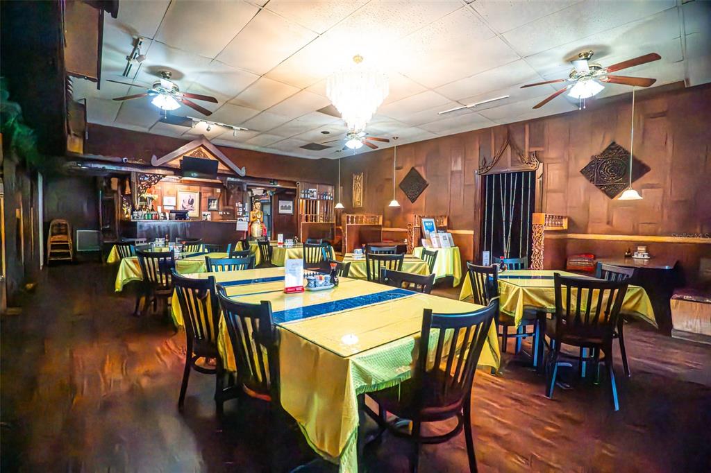 A restaurant dining room features wooden walls, yellow tablecloths, and multiple ceiling fans — 5414 MAIN STREET, NEW PORT RICHEY, FL