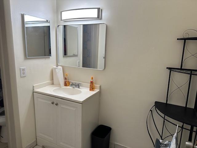 A bathroom vanity with a white cabinet, rectangular mirror, and a black metal corner shelf — 6505 WINFIELD Boulevard # 14, Margate FL 33063, MARGATE, FL