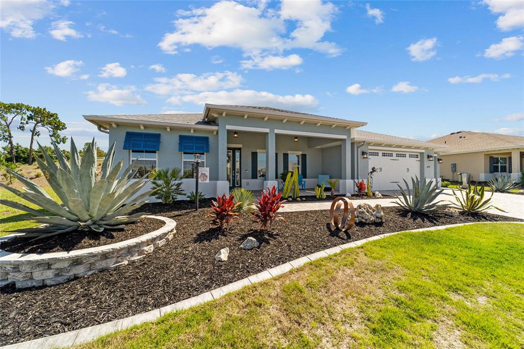 A single-story house with a blue exterior, a covered porch, and a landscaped front yard — 10298 SW 96TH LOOP, OCALA, FL