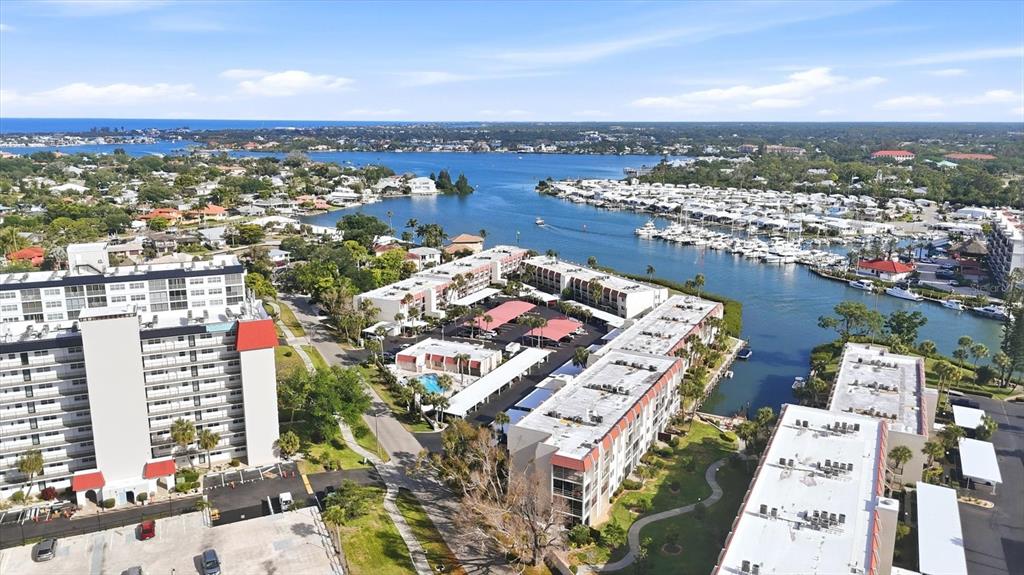 An aerial view shows several multi-story apartment buildings near a marina and a waterway — 260 SANTA MARIA STREET UNIT 105, VENICE, FL