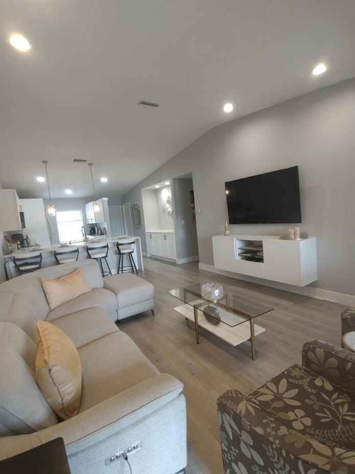 A living room with a sectional sofa, glass coffee table, and wall-mounted television — 18768 Argosy Drive, Boca Raton FL 33496, BOCA RATON, FL