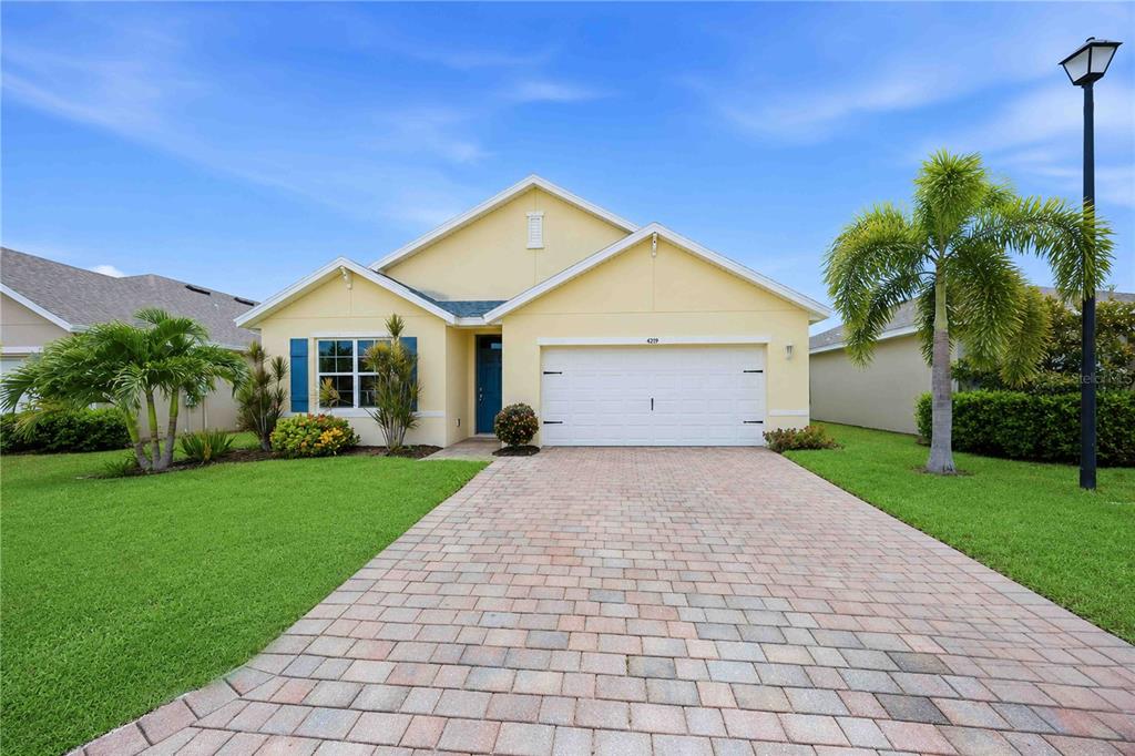 A single-story yellow house with a two-car garage and a paved driveway — 4219 MANATEE LANE, PUNTA GORDA, FL