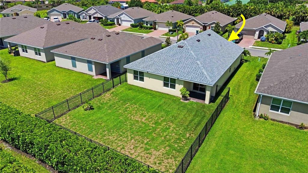 An aerial view shows the backyard and roof of a suburban house with a fence — 4219 MANATEE LANE, PUNTA GORDA, FL