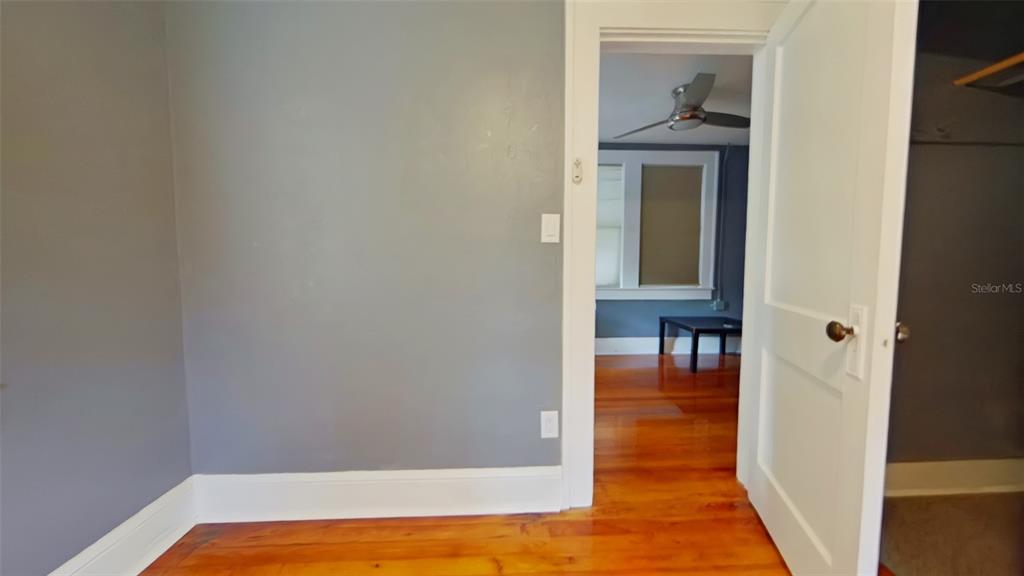 A view from a room with gray walls and hardwood floors into an adjacent room — 1412 NW 3RD AVENUE UNIT Upstairs, GAINESVILLE, FL