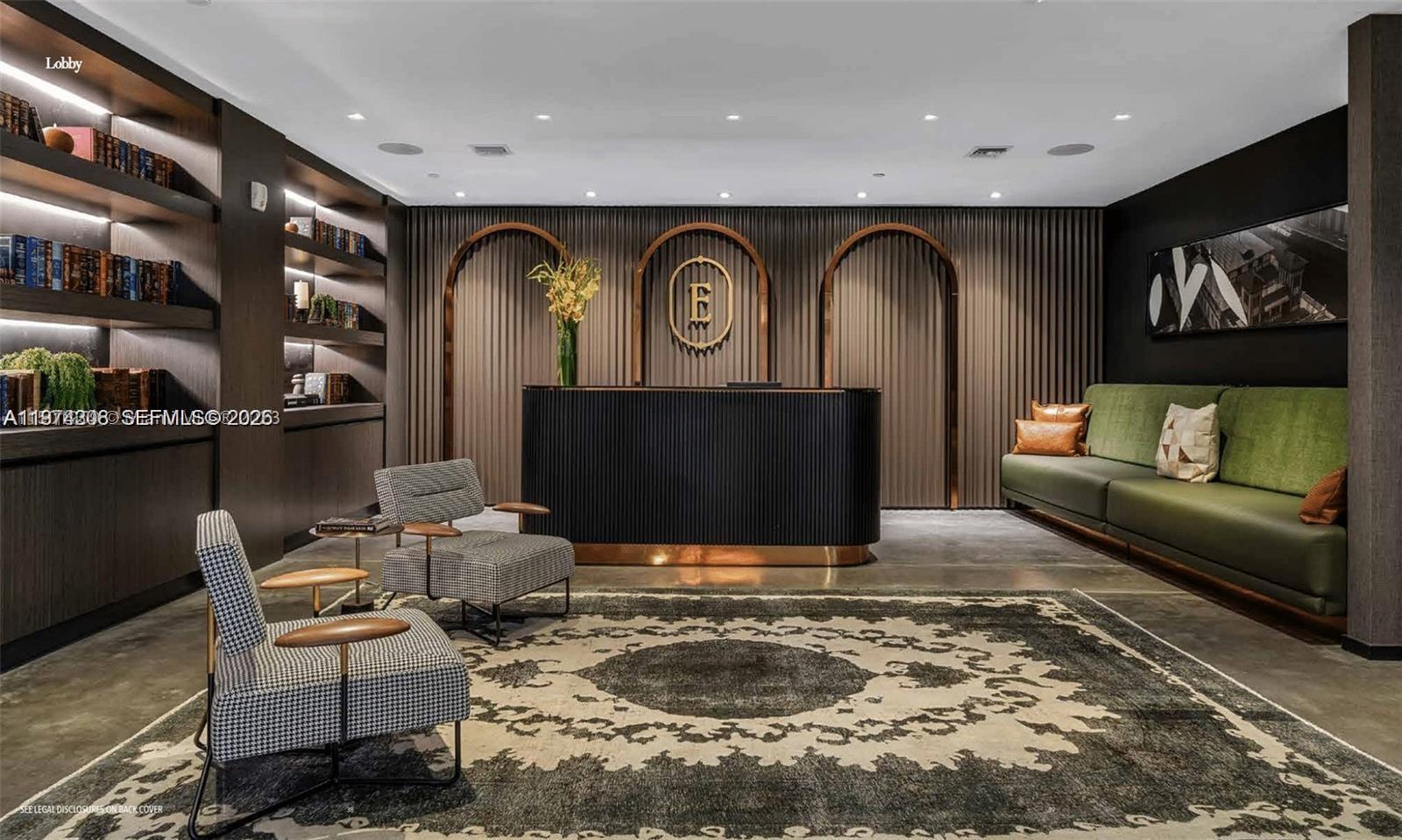 A modern lobby features a dark reception desk, patterned armchairs, a green sofa, and bookshelves — 398 NE 5th St # 1915, Miami FL 33132, MIAMI, FL