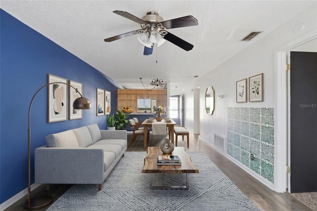 A living room features a blue accent wall, a gray sofa, and a wood coffee table — 39132 COUNTY ROAD 54 UNIT 2216, ZEPHYRHILLS, FL