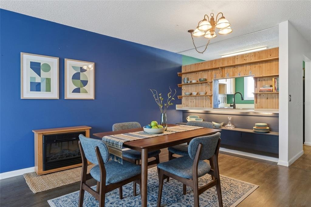 A dining room features a blue accent wall, wooden shelving, and a wooden dining set — 39132 COUNTY ROAD 54 UNIT 2216, ZEPHYRHILLS, FL