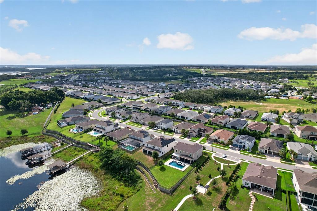 An aerial view of a suburban neighborhood featuring houses with pools near a lake — 3399 BUOY CIRCLE, WINTER GARDEN, FL