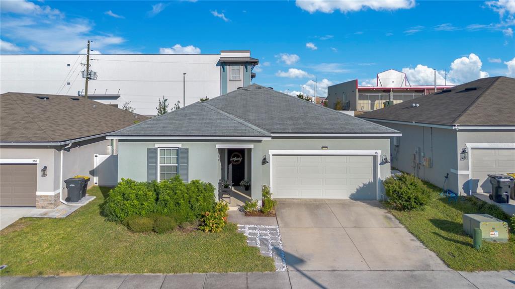 A single-story house features a gray exterior, a two-car garage, and a front lawn — 354 CASA VERANO LANE, DAVENPORT, FL