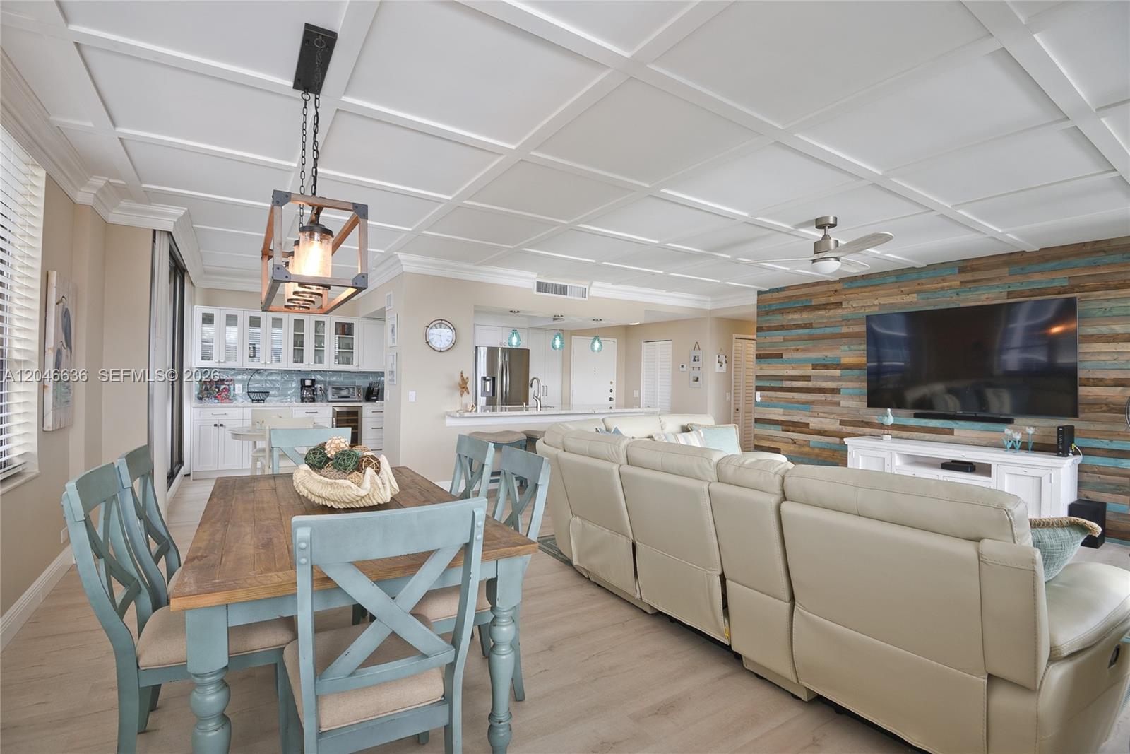 An open-concept living and dining area features a coffered ceiling and a wood-paneled accent wall — 3505 S Ocean Dr # 1505, Hollywood FL 33019, HOLLYWOOD, FL