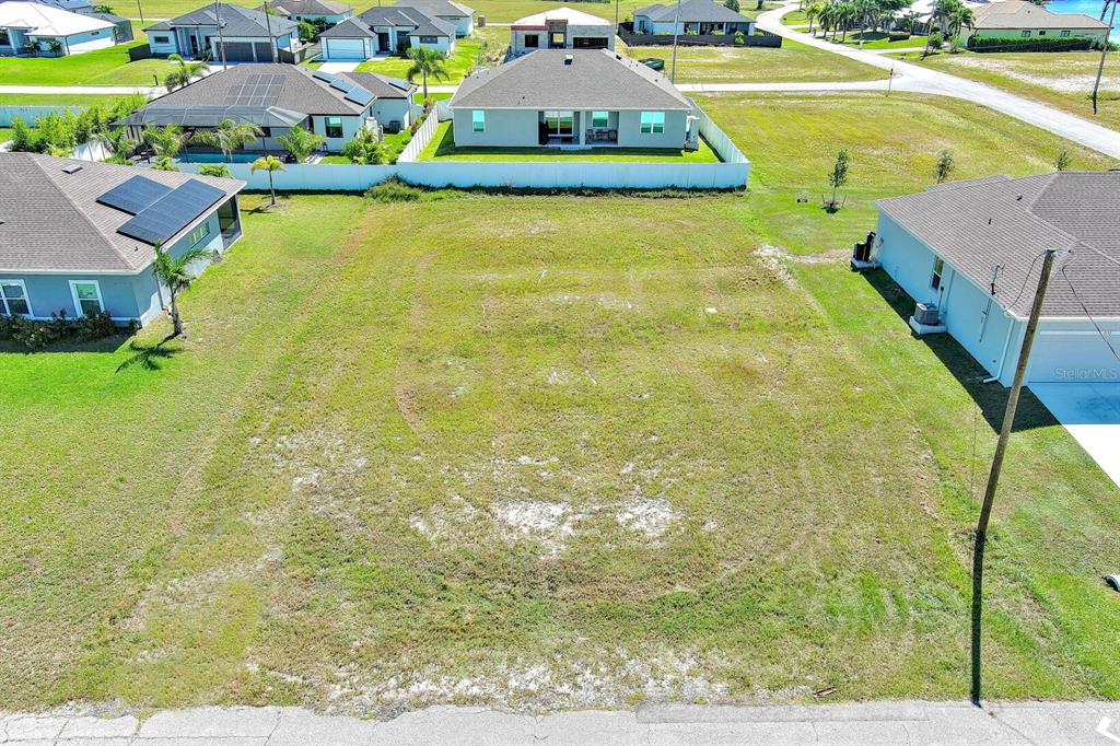 An aerial view of a vacant residential lot situated between two existing houses — 3548 NW 21ST TERRACE, CAPE CORAL, FL