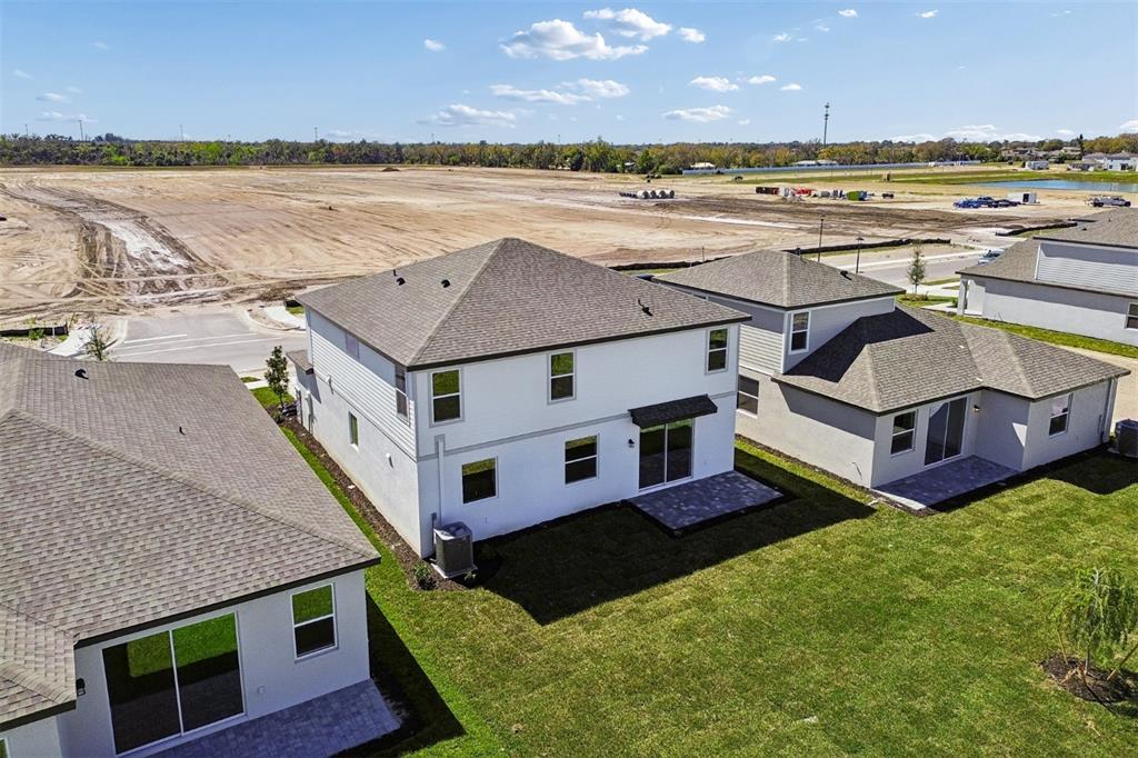 An aerial view of the backyards and rear exteriors of three suburban houses — 4610 OUTHAUL RUN, PALMETTO, FL