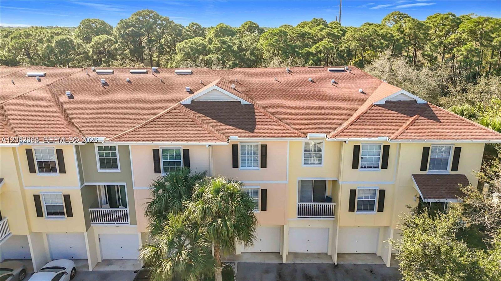 An aerial view of a multi-story townhouse complex with a brown shingled roof — 125 Galicia Way # 204, Jupiter FL 33458, JUPITER, FL