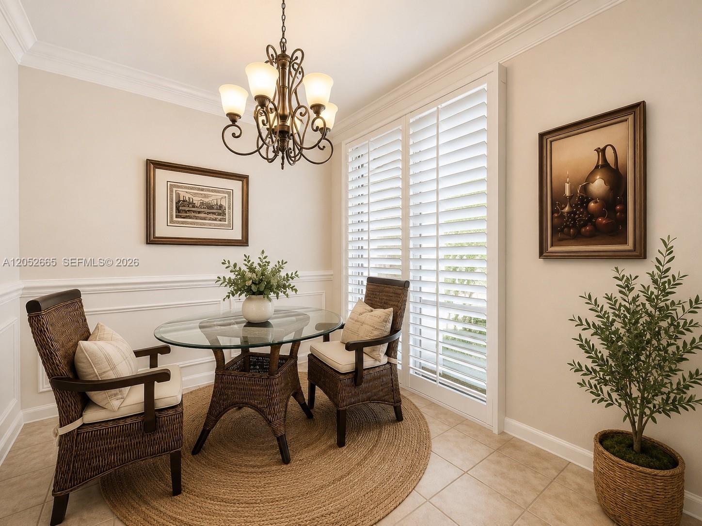 A dining nook features a glass-topped wicker table, two chairs, and plantation shutters — 125 Galicia Way # 204, Jupiter FL 33458, JUPITER, FL