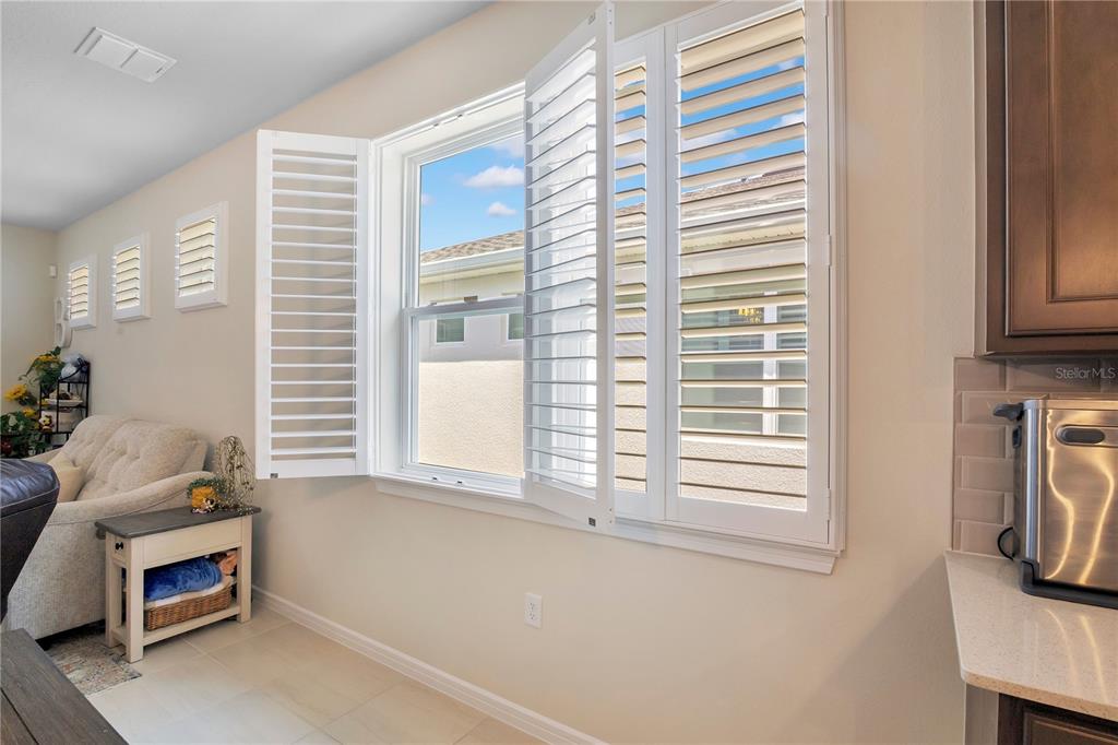 A living room features two beige sofas, a dark leather recliner, and a sliding glass door — 15157 AQUA SOL LANE, WINTER GARDEN, FL