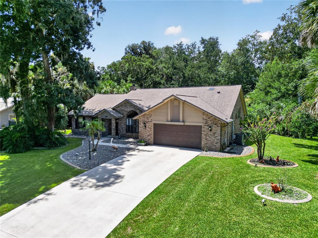An exterior view of a single-story brick house with a two-car garage and driveway — 1384 ALEUT LANE, ORMOND BEACH, FL