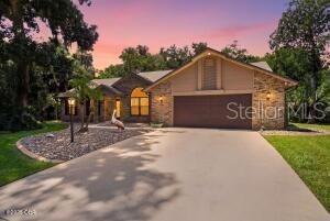A single-story house with a stone facade, a two-car garage, and a concrete driveway — 1384 ALEUT LANE, ORMOND BEACH, FL