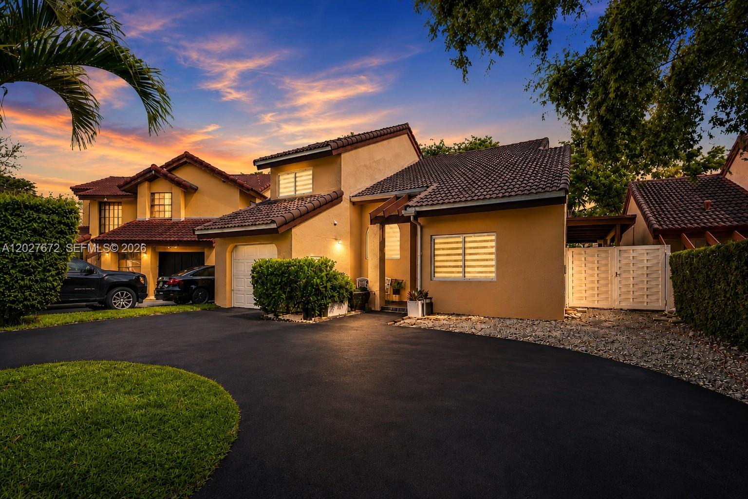 A two-story stucco house with a tiled roof and a paved driveway at sunset — 12745 SW 62nd Ter, Miami FL 33183, MIAMI, FL