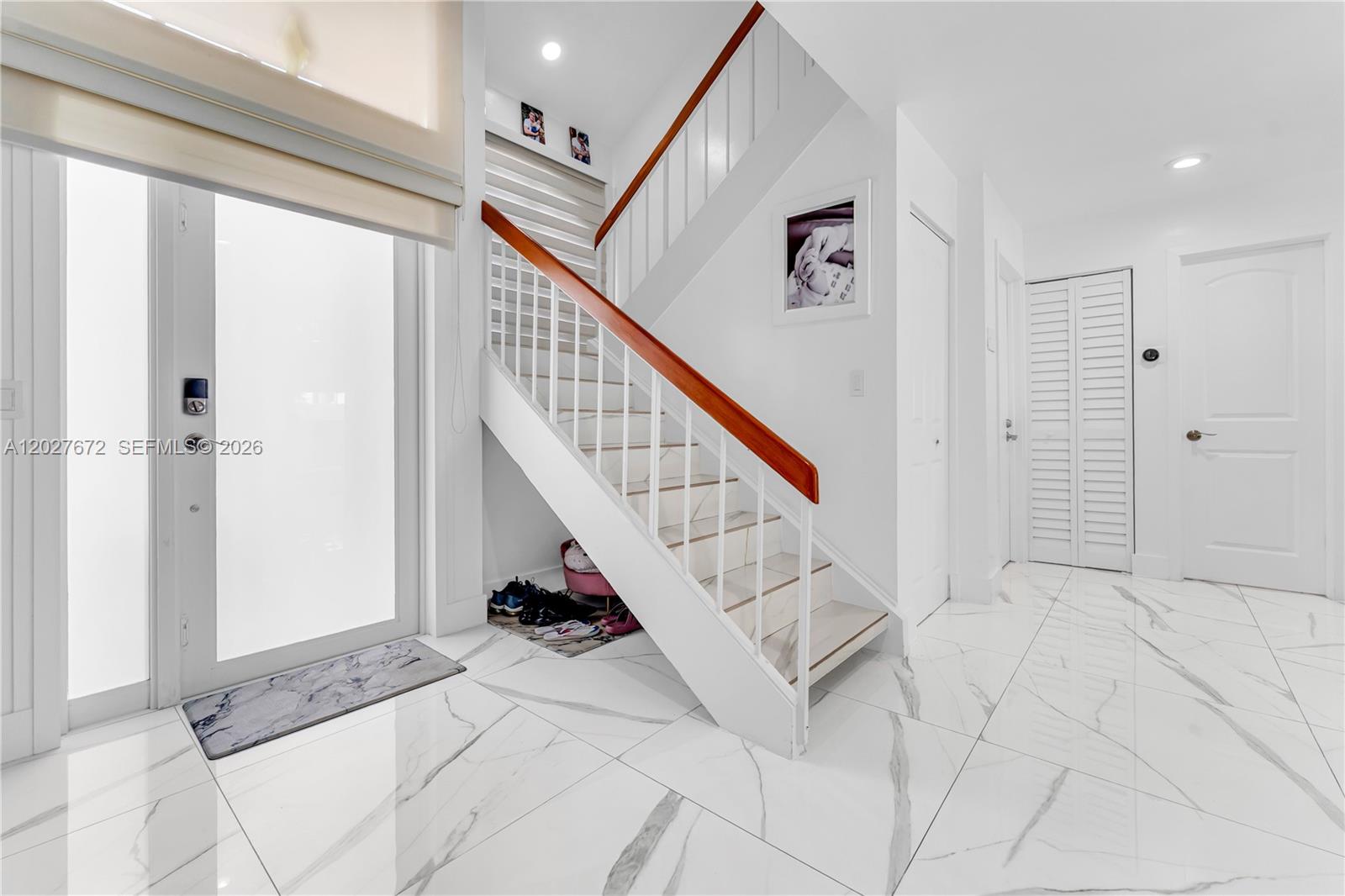 A bright entryway features white marble-look tile flooring and a staircase with wooden handrails — 12745 SW 62nd Ter, Miami FL 33183, MIAMI, FL