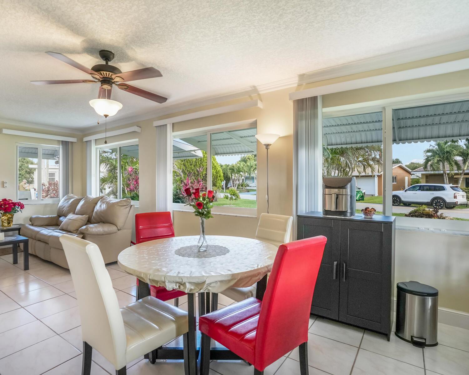 A dining area with a round table, red and white chairs, and a living room — 4712 Mainland Drive, Tamarac FL 33319, TAMARAC, FL