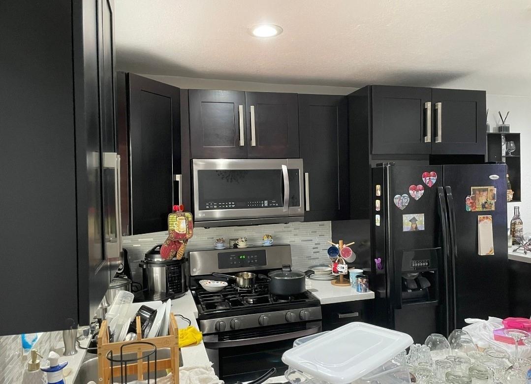 A kitchen features dark cabinets, stainless steel appliances, a gas range, and a tiled backsplash — 4655 Palm Avenue, Hialeah FL 33012, HIALEAH, FL