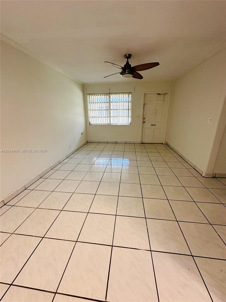 An empty room features white walls, a ceiling fan, and light-colored tiled flooring — 2319 Jackson St # 6, Hollywood FL 33020, HOLLYWOOD, FL