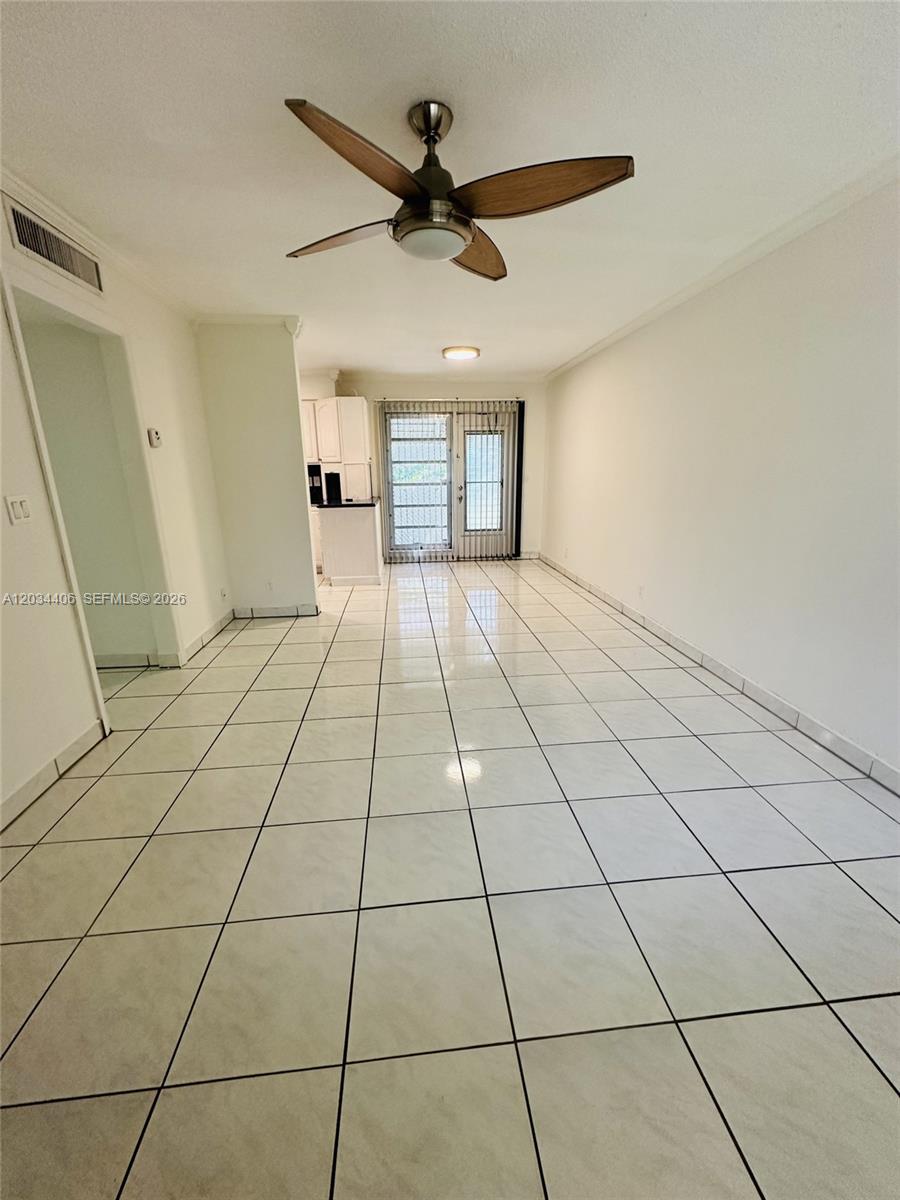 An empty room with white tile flooring, a ceiling fan, and a glass sliding door — 2319 Jackson St # 6, Hollywood FL 33020, HOLLYWOOD, FL