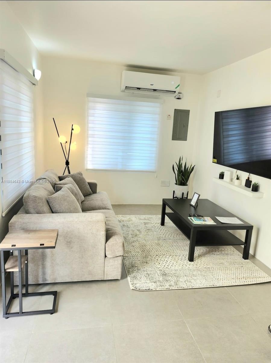 A living room features a gray sofa, a black coffee table, and a wall-mounted television — 00 Norbrook, Kingston, Jamaica # 1, NA, NA