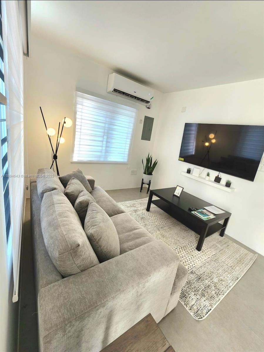 A modern living room features a grey sofa, a black coffee table, and a wall-mounted television — 00 Norbrook, Kingston, Jamaica # 1, NA, NA