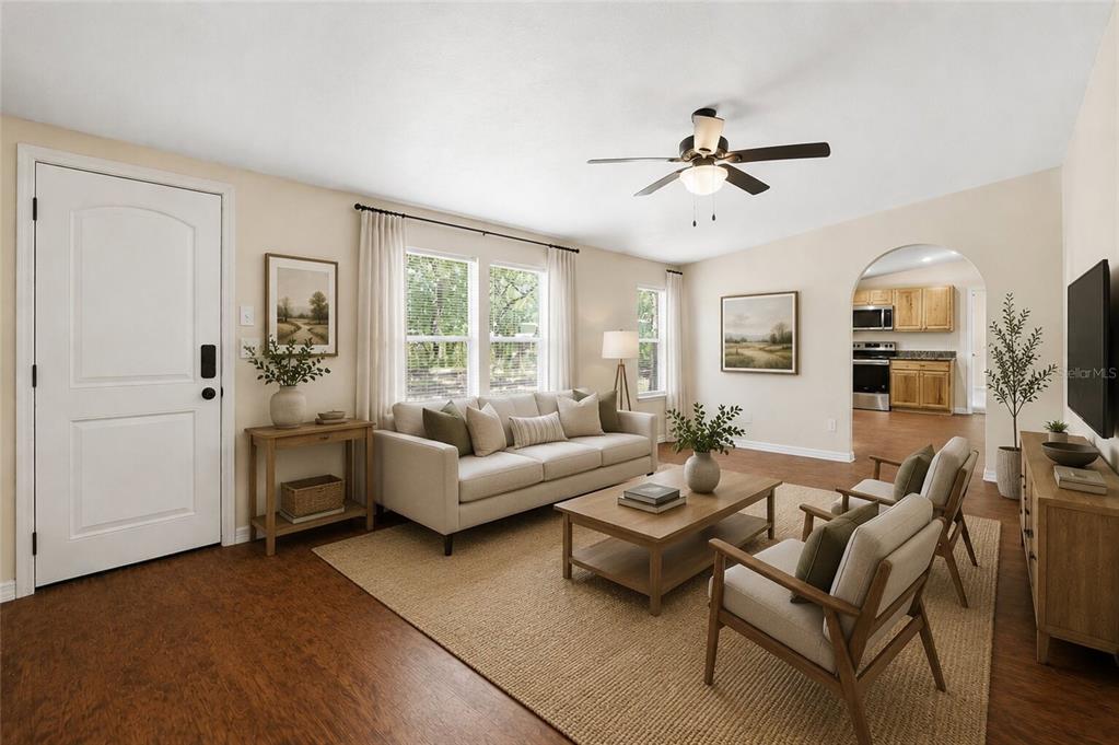 A living room features a sofa, two armchairs, a coffee table, and a ceiling fan — 7651 NW 153RD LANE, CHIEFLAND, FL