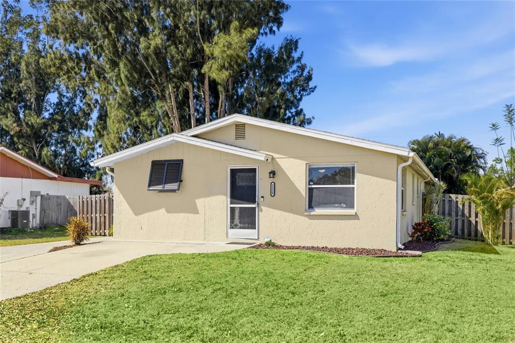 A single-story, light yellow house with a front lawn and a concrete driveway — 5320 MOELLER AVENUE, SARASOTA, FL