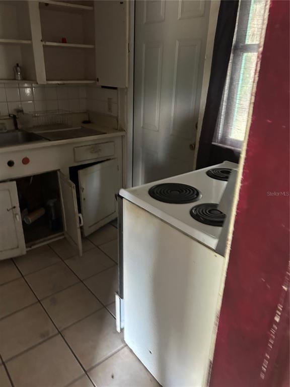 A kitchen features white cabinets, a tiled floor, and a white electric stove — 2018 BRACKLAND STREET, JACKSONVILLE, FL