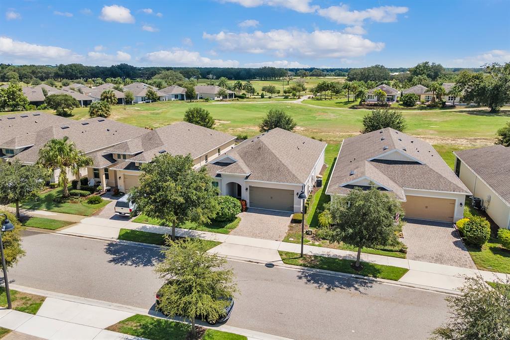 An aerial view of suburban houses with attached garages bordering a green golf course — 2233 ANTILLES CLUB DRIVE, KISSIMMEE, FL