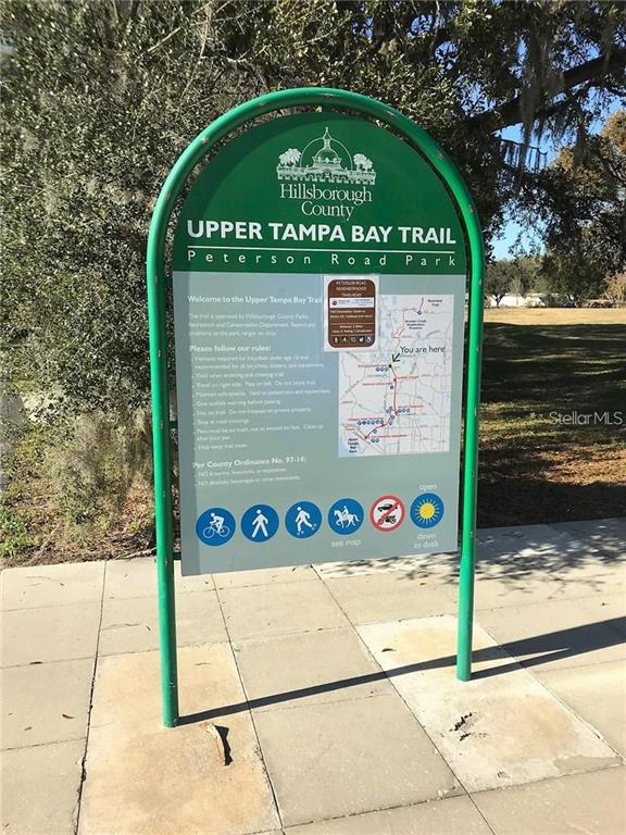 A green sign for the Upper Tampa Bay Trail stands on a paved path — 15025 RAILS ROAD, ODESSA, FL