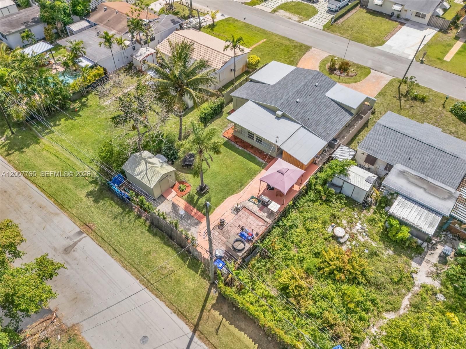 An aerial view shows a house with a fenced backyard, patio, gazebo, and storage shed — 921 N 31st Ct, Hollywood FL 33021, HOLLYWOOD, FL