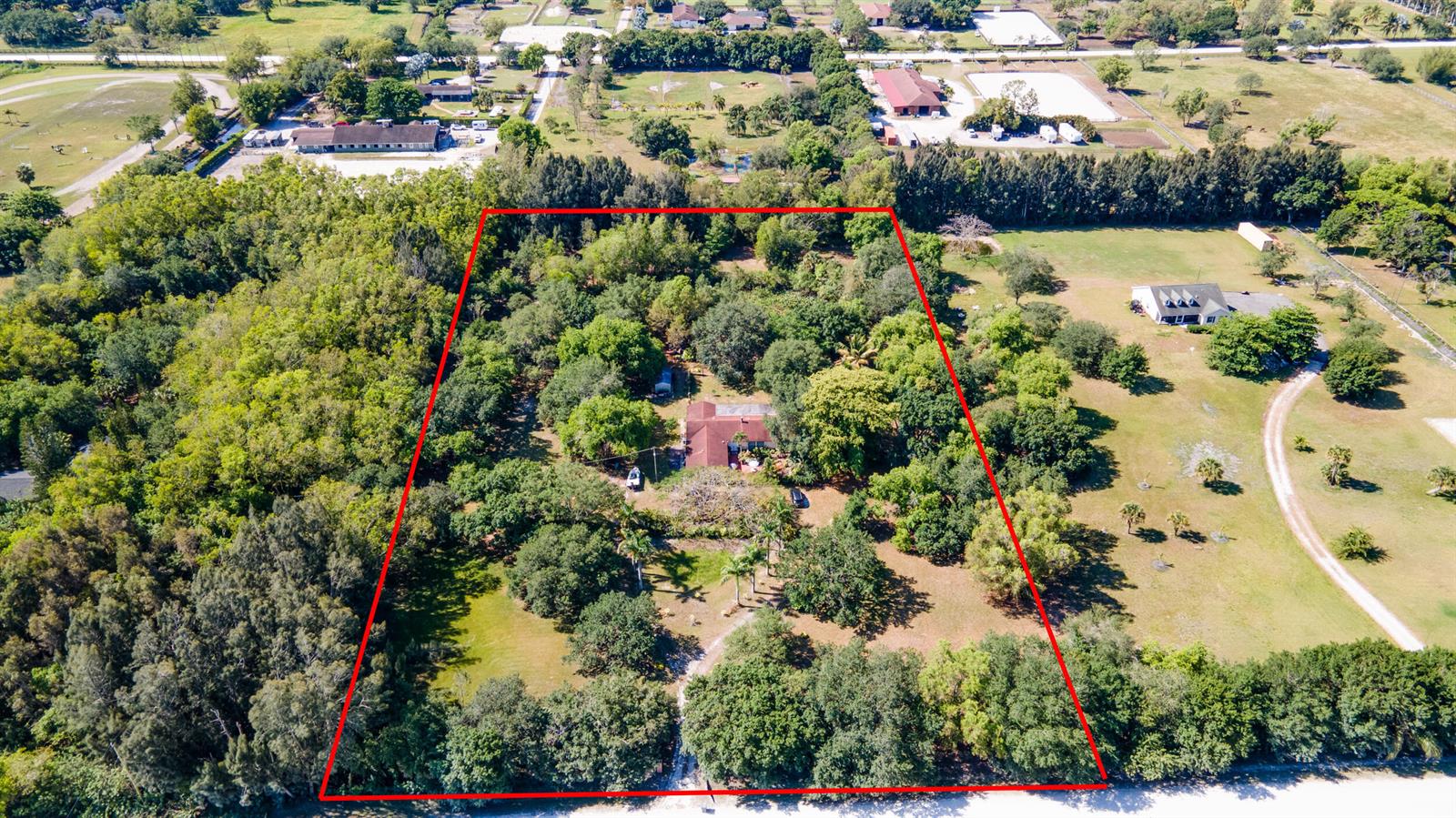 An aerial view shows a house surrounded by trees within a red-outlined property boundary — 16688 Rustic Road, Wellington FL 33470, WELLINGTON, FL