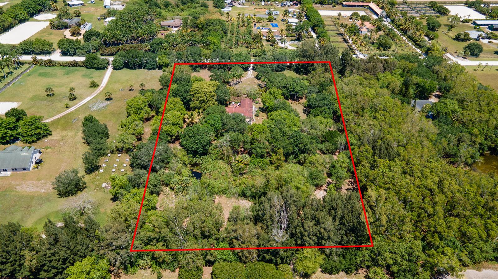 An aerial view shows a house surrounded by dense trees within a red-outlined property boundary — 16688 Rustic Road, Wellington FL 33470, WELLINGTON, FL