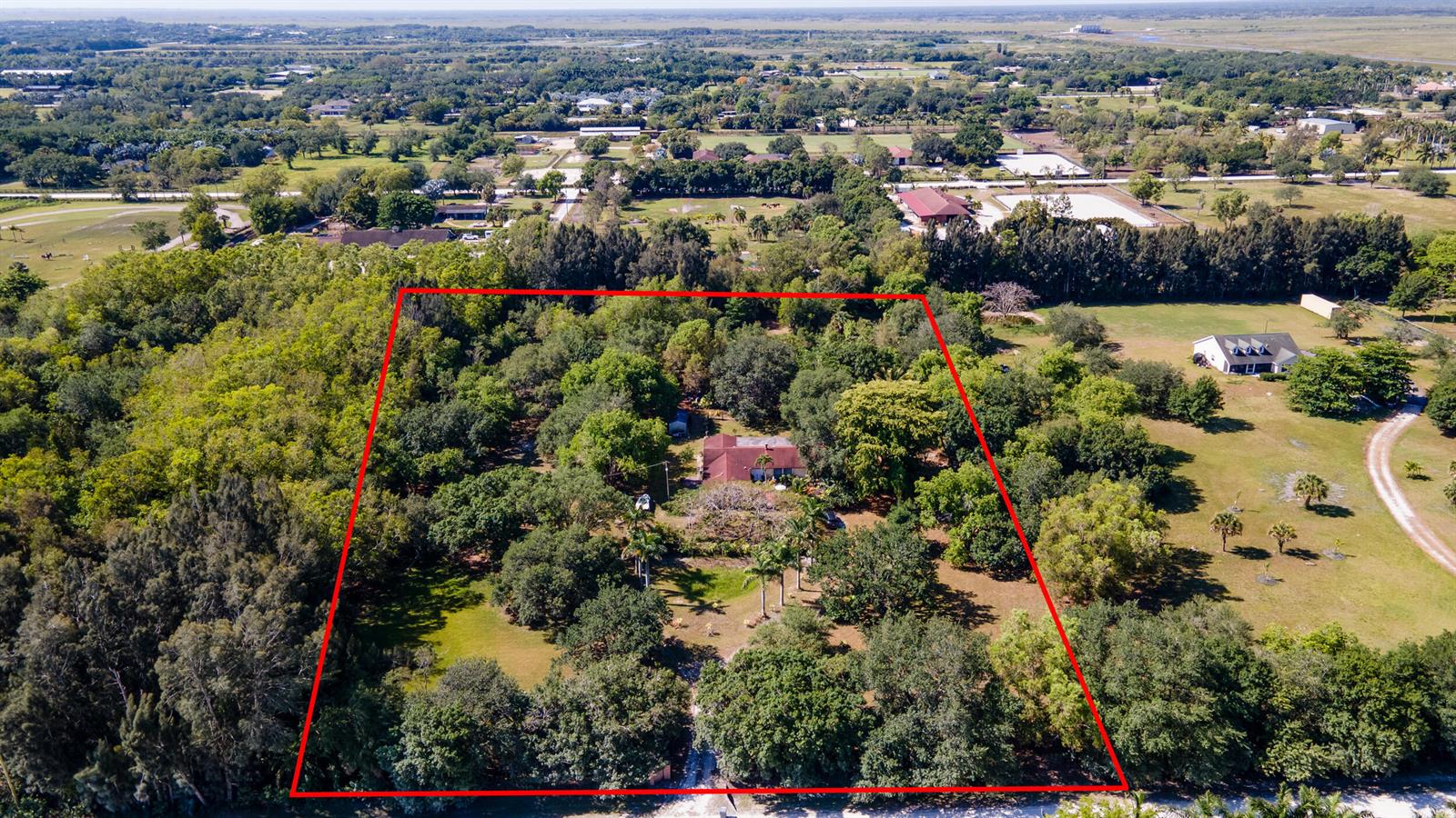 An aerial view shows a house surrounded by trees within a red-outlined property boundary — 16688 Rustic Road, Wellington FL 33470, WELLINGTON, FL