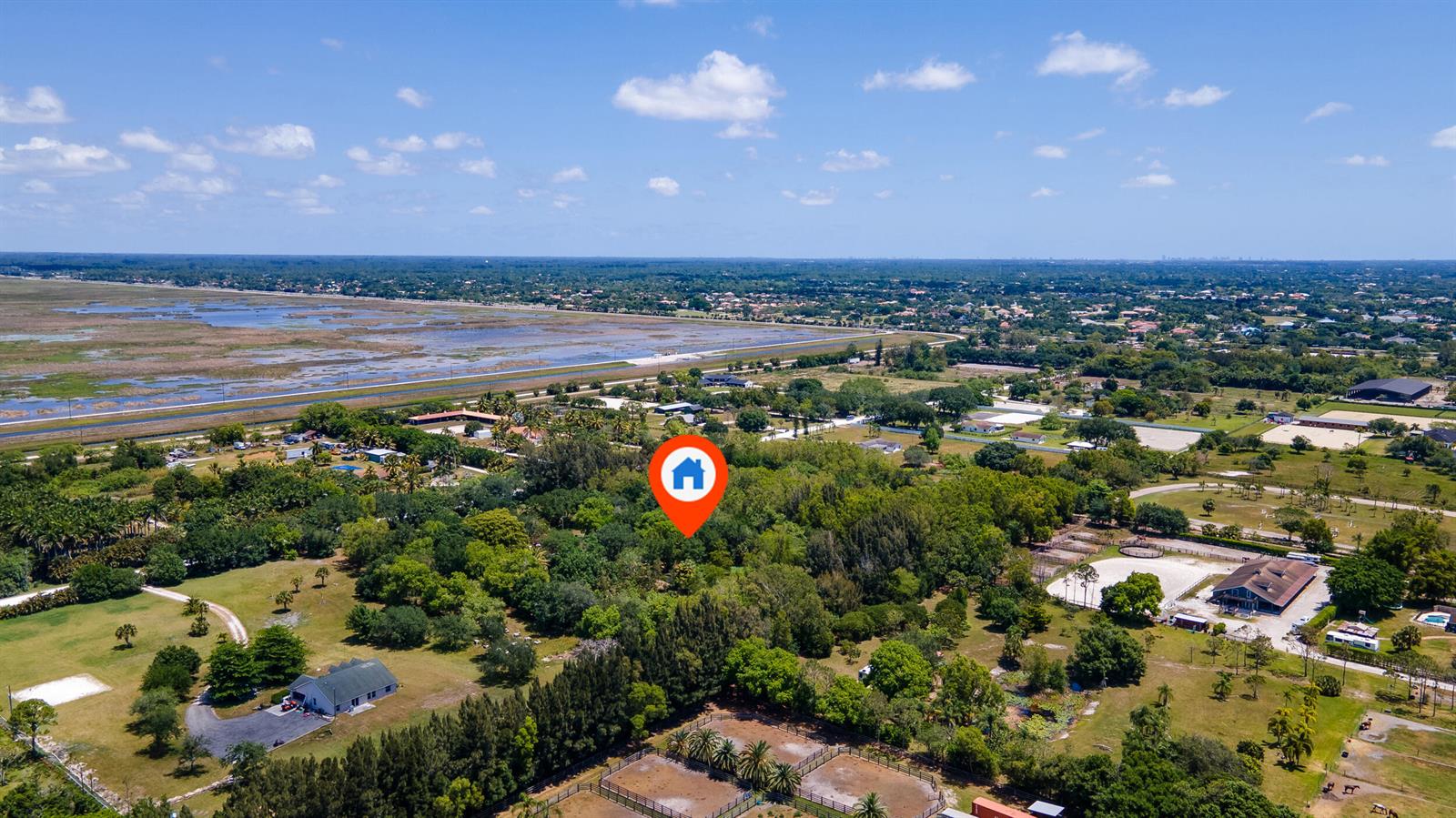 An aerial view shows a wooded property with a house icon marker and horse paddocks — 16688 Rustic Road, Wellington FL 33470, WELLINGTON, FL