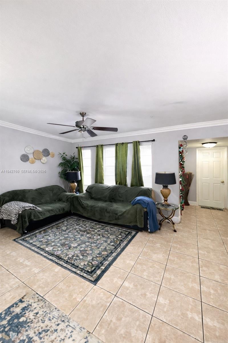 A living room features tiled floors, a ceiling fan, and two sofas with green covers — 2450 NW 85th Ave, Sunrise FL 33322, SUNRISE, FL