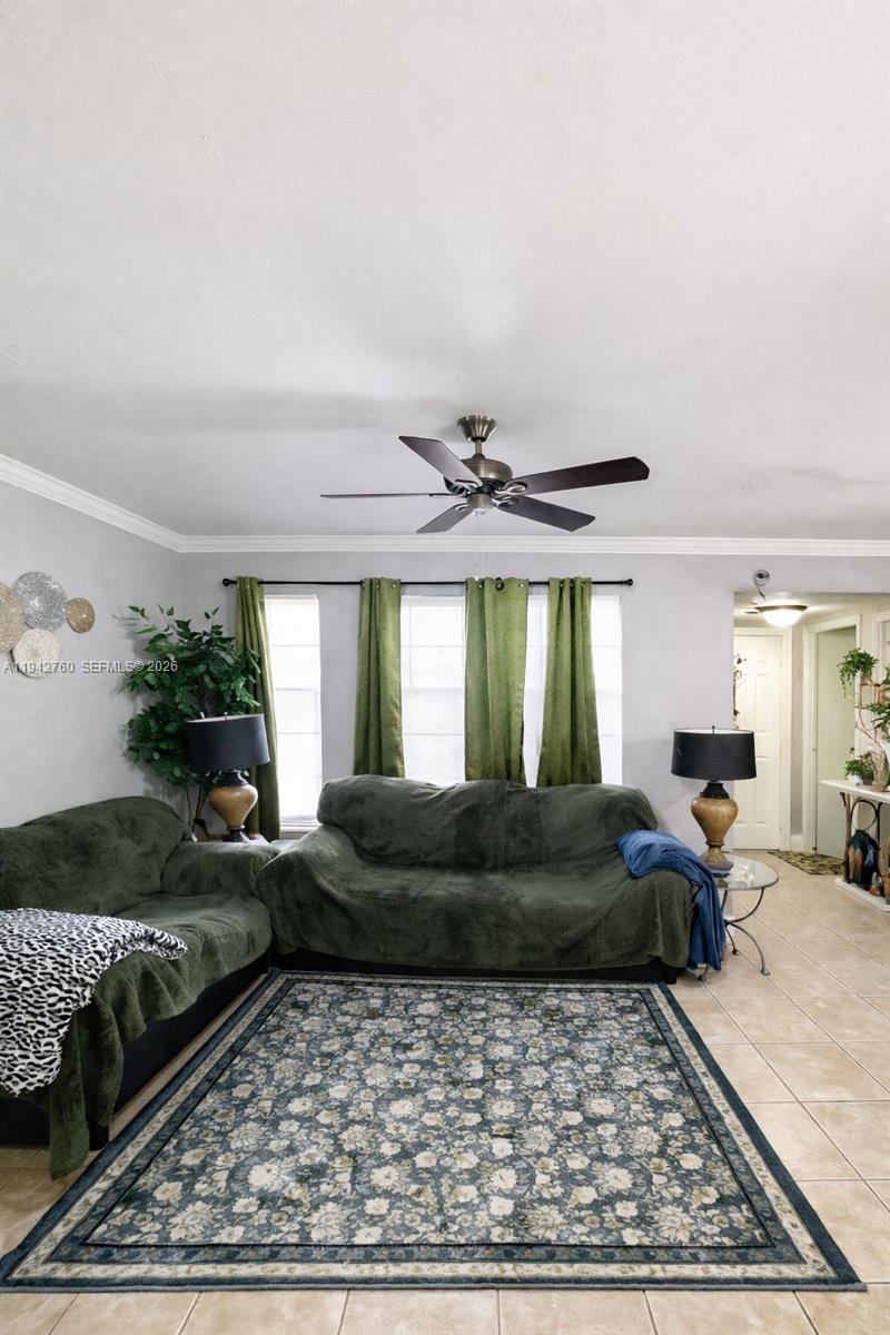 A living room features green sofas, a floral area rug, and olive green curtains — 2450 NW 85th Ave, Sunrise FL 33322, SUNRISE, FL