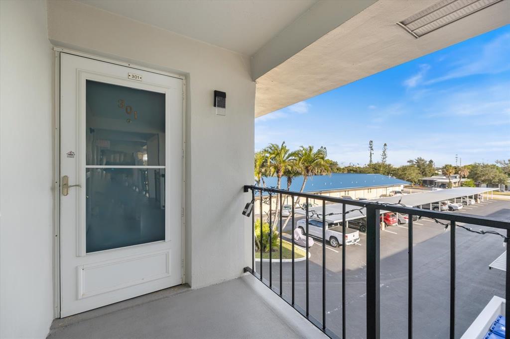 An exterior balcony features a white door labeled 301 and a black metal railing — 649 TAMIAMI TRAIL S UNIT 301, VENICE, FL