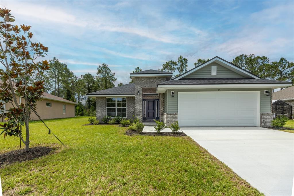A single-story house with a brick and siding exterior, a two-car garage, and a lawn — 73 PRICE LANE, PALM COAST, FL