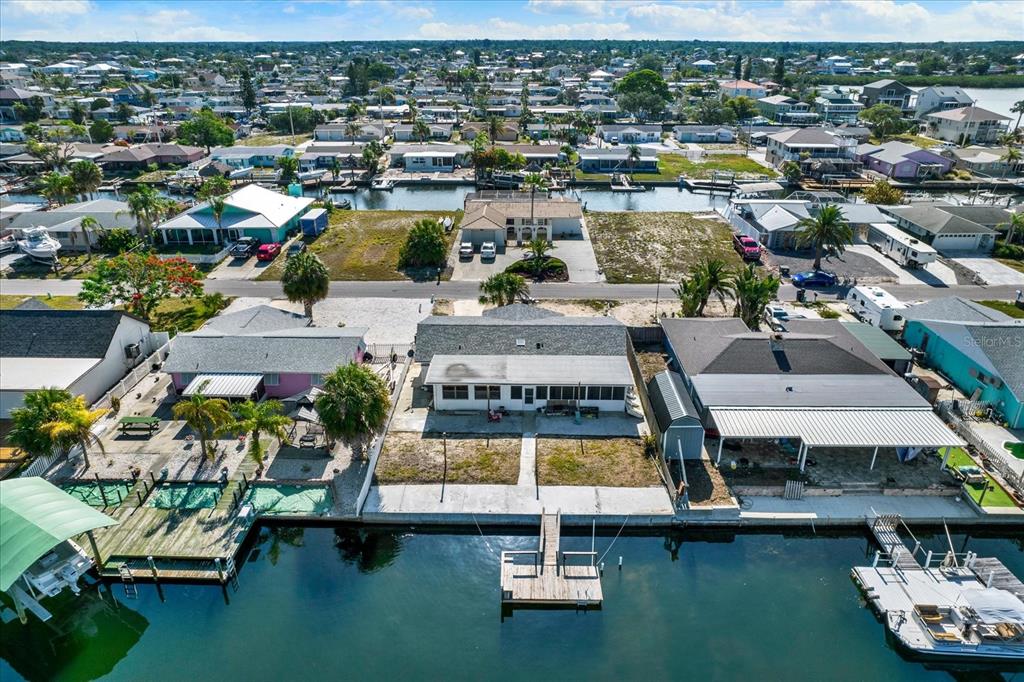 An aerial view shows a waterfront house with a private dock and a canal — 13605 GARRIS DRIVE, HUDSON, FL